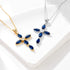 Gold and silver cross pendants with blue sapphire stones and diamond centers displayed on white surface