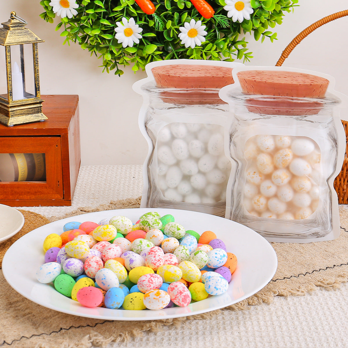 Two transparent jar bags filled with white and golden-speckled eggs placed behind a plate of colorful speckled eggs on a table.