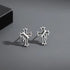 Silver stud earrings pair with vintage cross design and black antiqued details on gray background