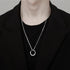 Silver chain necklace with circular pendant worn with black outfit