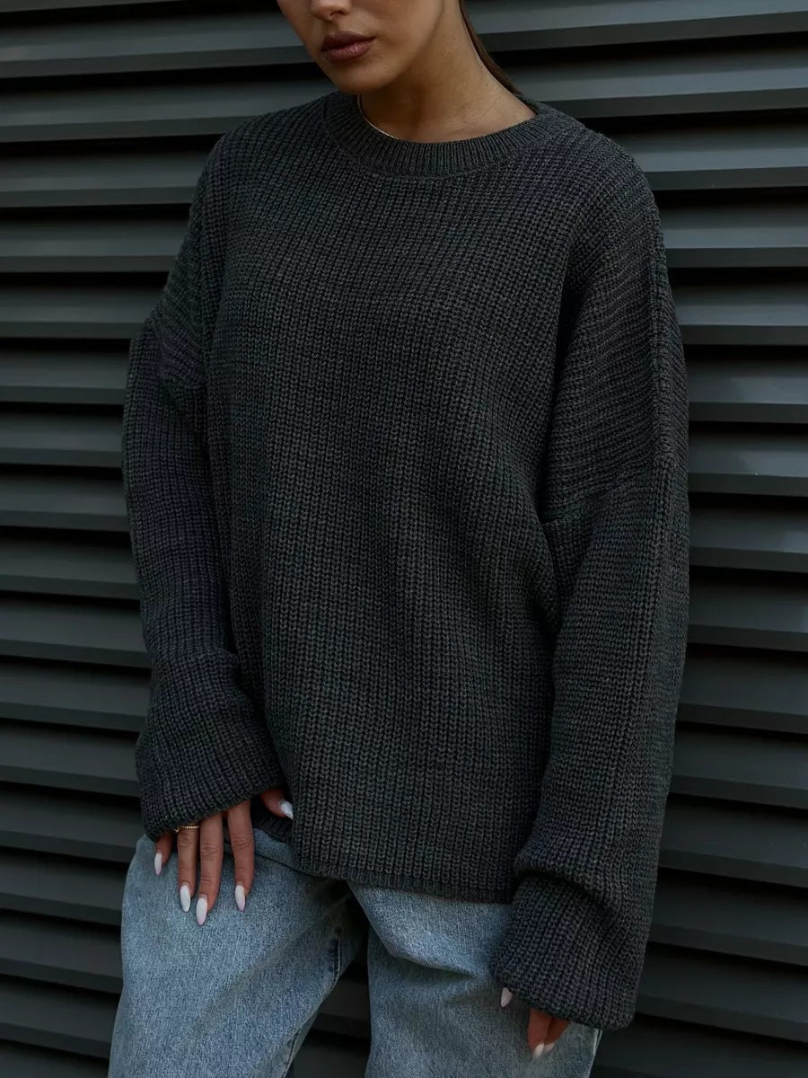 Close-up of charcoal grey chunky knit sweater with ribbed texture and relaxed fit, worn casually