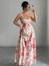 Woman taking a mirror selfie wearing a floral dress in a minimalistic setting.