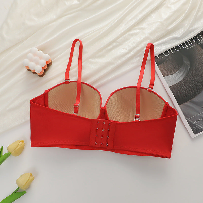 Back view of red bustier bra showing hook closures and adjustable straps on white background with yellow tulips