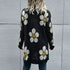 Back view of black daisy-print cardigan with a relaxed fit