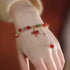 Elegant red agate bracelet with maple leaf charm and gold-tone details