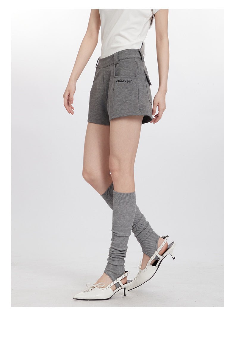 Side view of gray shorts with pockets, paired with leg warmers and white pointed slingbacks