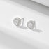 A pair of silver stud earrings with round center diamonds encircled by pavé diamond halos on minimalist white background