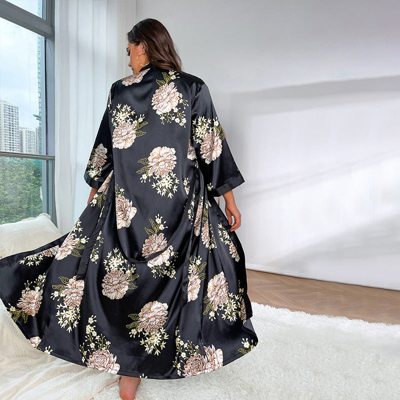 Back view of the black and beige floral satin long robe, displaying the full length and floral print with city buildings visible