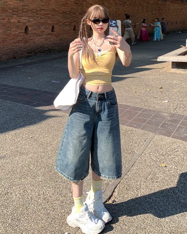 Front view, selfie-style angle – Y2K bermuda jean shorts with raw hem and relaxed urban fit.