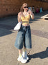 Front view, selfie-style angle – Y2K bermuda jean shorts with raw hem and relaxed urban fit.