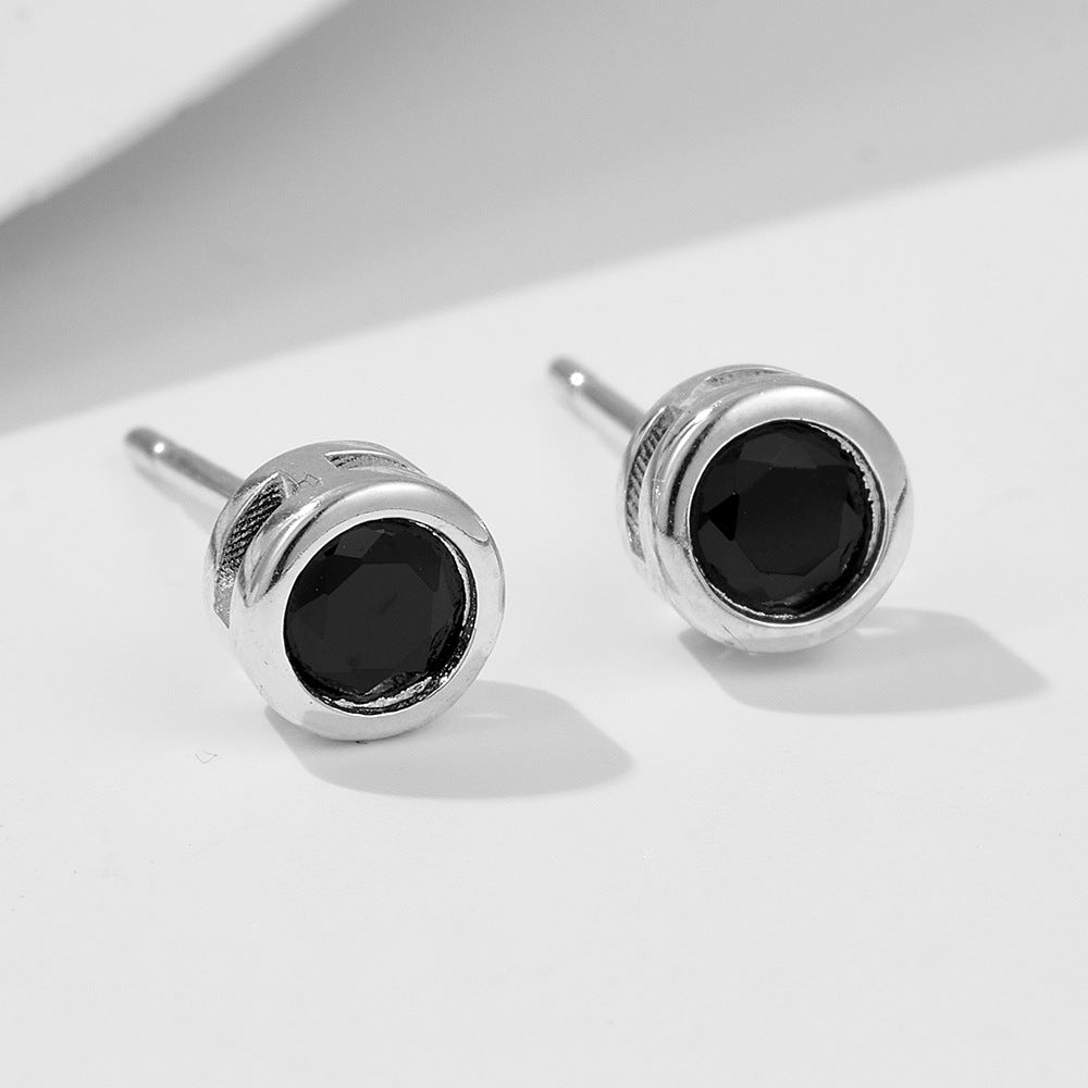 Silver-plated round stud earrings with black cubic zirconia stones in bezel setting, studio shot