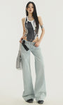 Front view, full-body shot with bag: Low-rise straight jeans in light denim, styled with chain belt.