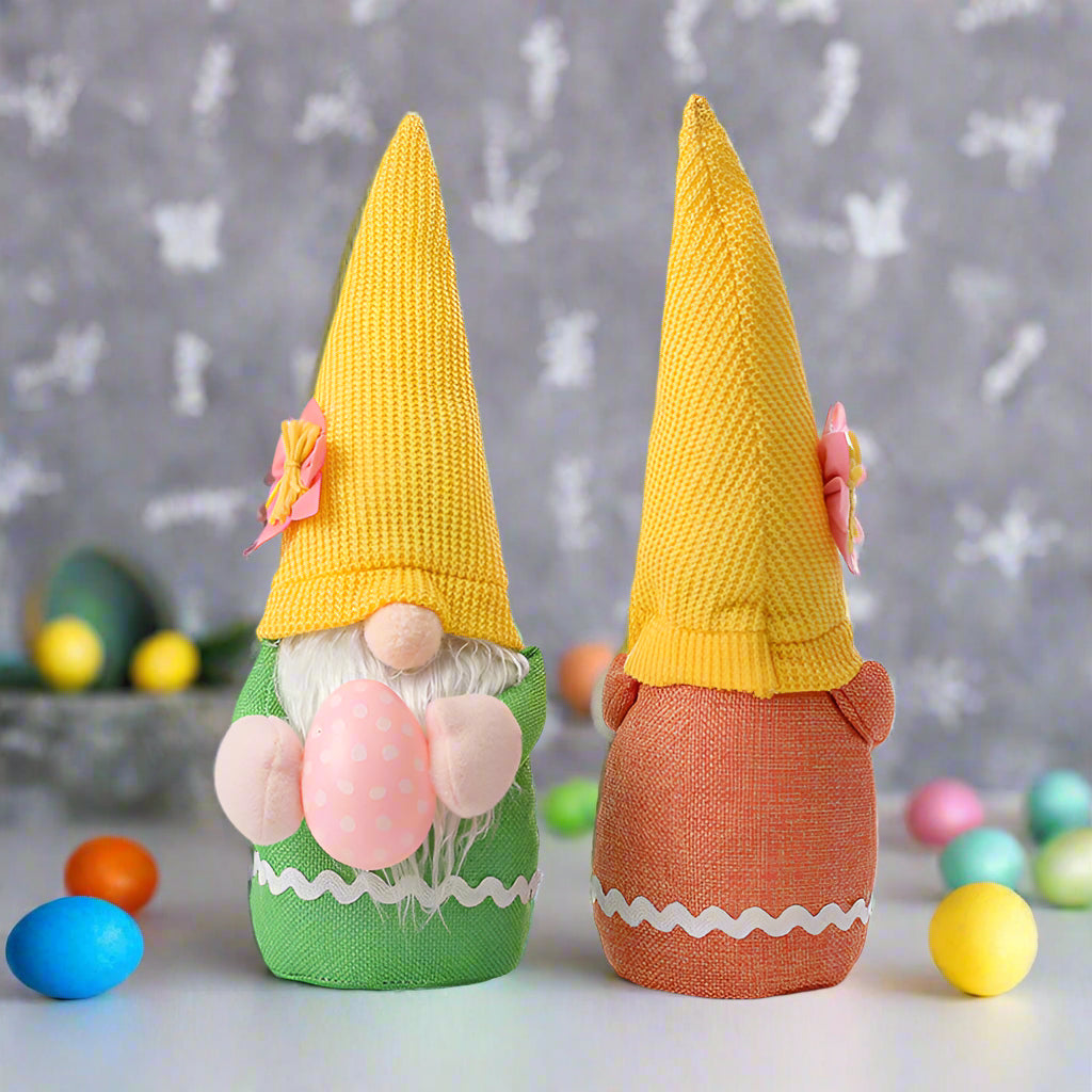 Front and back view of two Easter gnome plush toys with yellow hats, one in green and one in orange, featuring floral details.