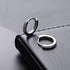 Two zirconium pavé silver hoop earrings on black leather surface