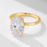 A gold solitaire ring with large oval-cut diamond center stone in prong setting, displayed on white surface with soft shadow