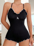  A detailed look at the ribbed fabric, white ruffle trim, and bow accent on a fitted black romper with thin straps.