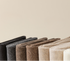 Row of knit leg warmers in neutral tones from black to cream