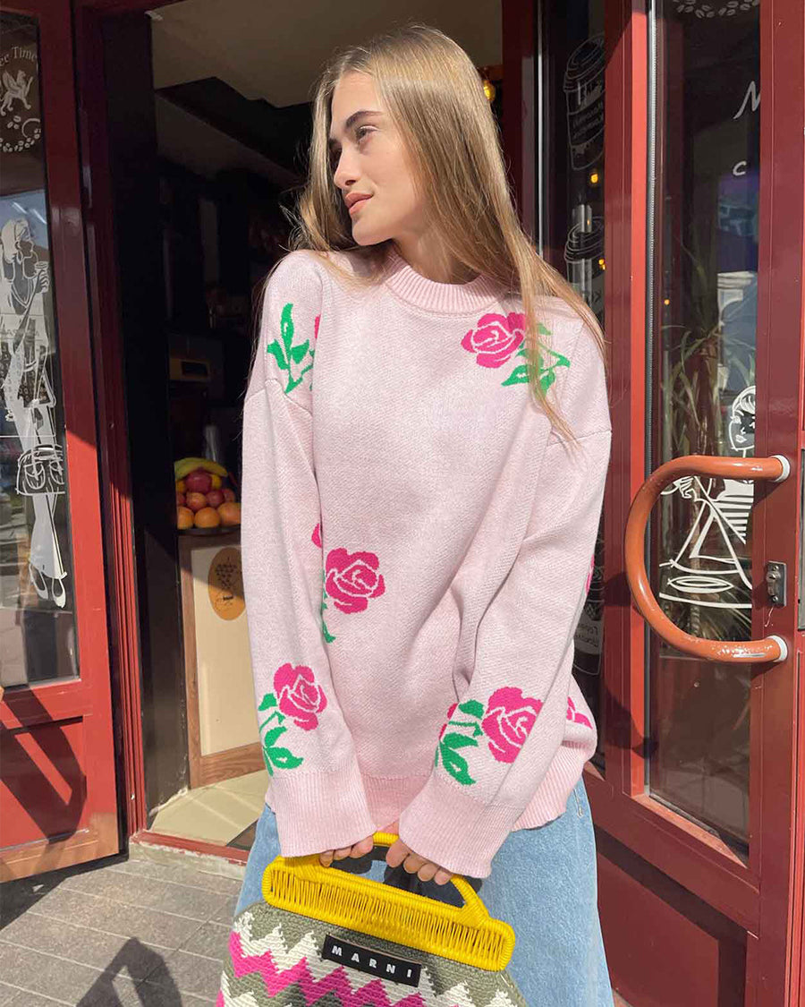 Light pink oversized sweater with rose print pattern, worn with jeans and Marni handbag, casual street style