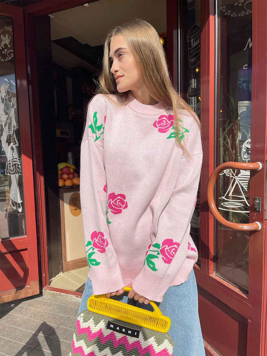 Light pink oversized sweater with rose print pattern, worn with jeans and Marni handbag, casual street style