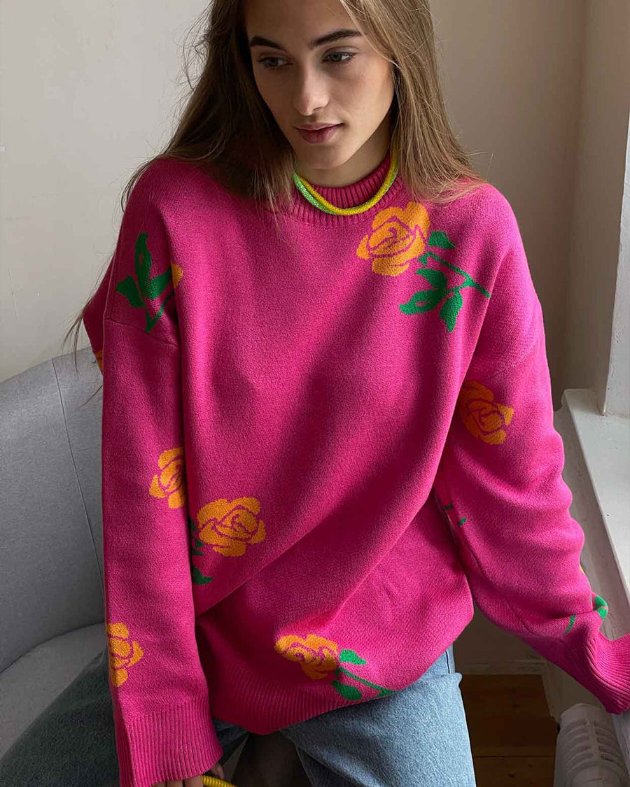 Hot pink knit sweater with yellow rose pattern and green leaves, styled with light wash denim