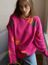 Hot pink knit sweater with yellow rose pattern and green leaves, styled with light wash denim