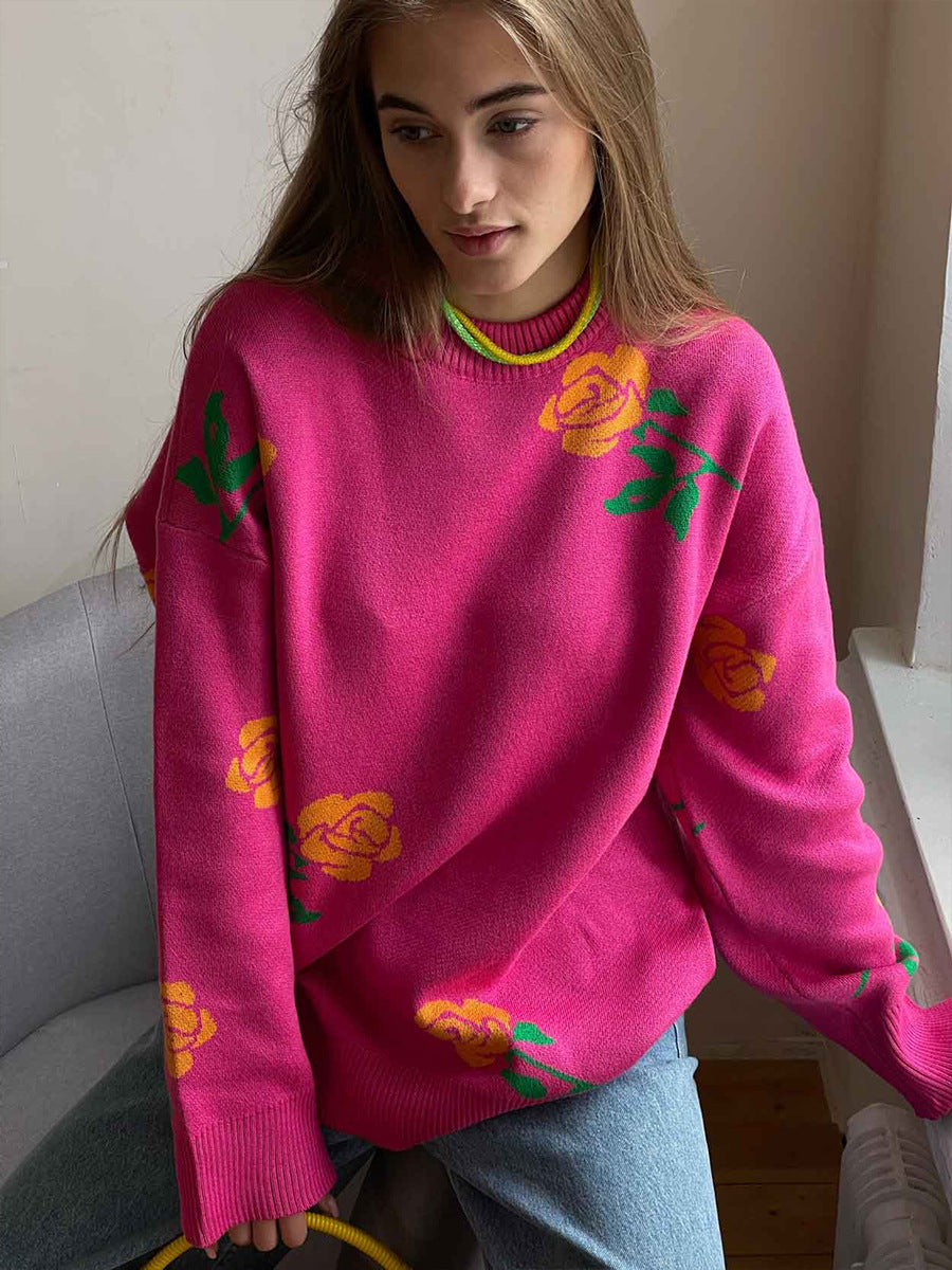 Hot pink knit sweater with yellow rose pattern and green leaves, styled with light wash denim