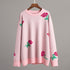 Light pink oversized sweater with rose print and ribbed trim displayed on wooden hanger