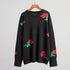 Black knit sweater with red rose pattern displayed on wooden hanger against white background