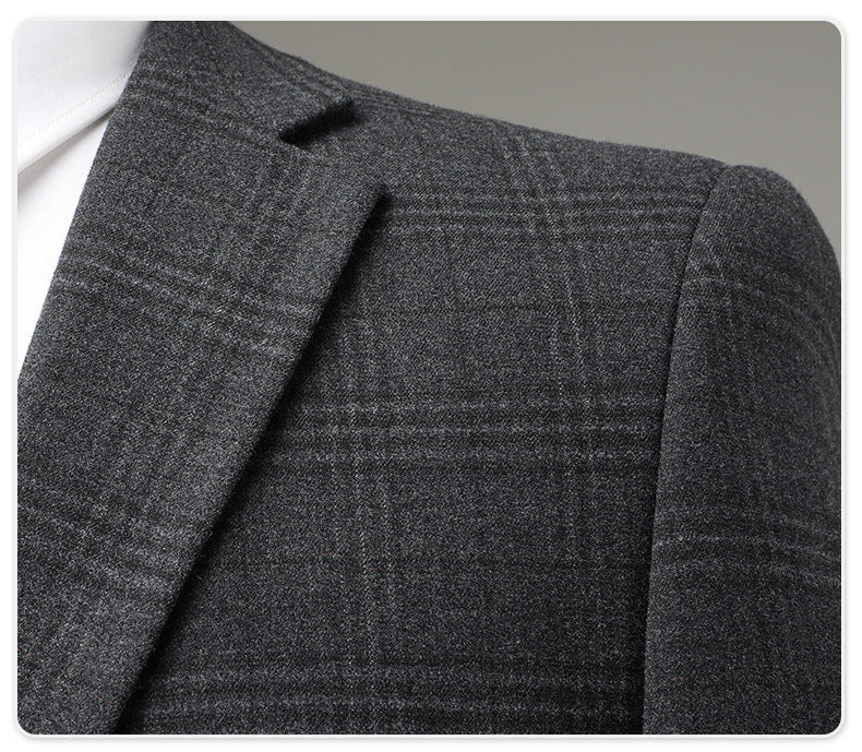 Detail of suit jacket lapel showing subtle windowpane pattern in charcoal wool fabric