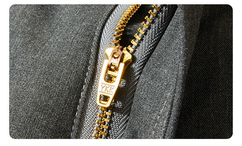 Close-up of gold YKK zipper on gray trouser fabric