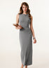 Female model in a light gray ribbed bodycon maxi dress, styled with a notebook for a casual yet elegant aesthetic.