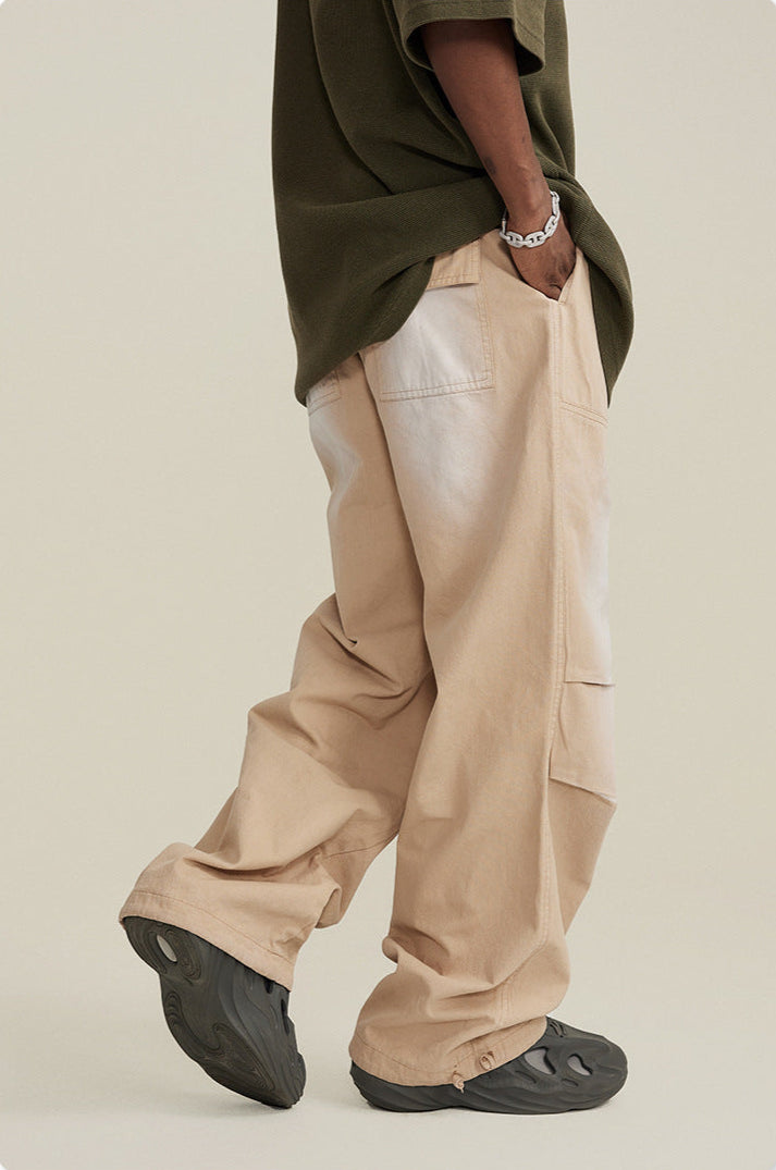 Side view of model in olive t-shirt, beige wide-leg pants and black foam shoes