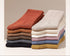 Stacked neutral-colored socks in sienna, beige, white and light gray against white background