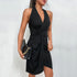 Black halter dress with wrap design and ruched side detail, accessorized with black snakeskin bag and gold jewelry