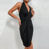 Close-up of black wrap halter dress showing draped front detail and fitted silhouette against white background