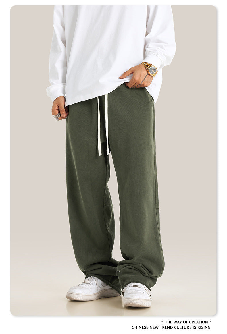 Person wearing white long-sleeve shirt and olive green sweatpants with white drawstring and side pockets