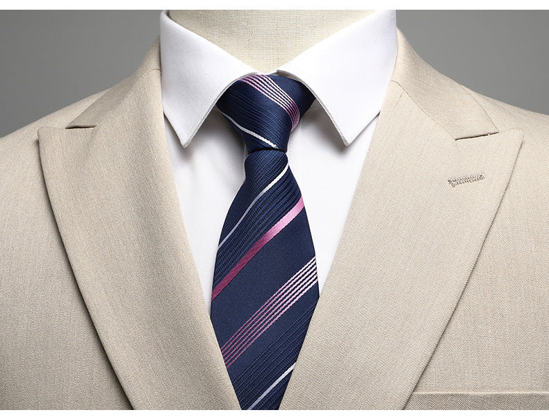 Close-up of navy striped tie with pink accents against beige suit lapel