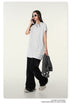 Model with dark hair wearing white t-shirt, black pants, white sunglasses, holding phone and gray jacket