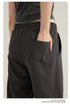 Close-up of hand in back pocket of black cargo pants with elasticated waist