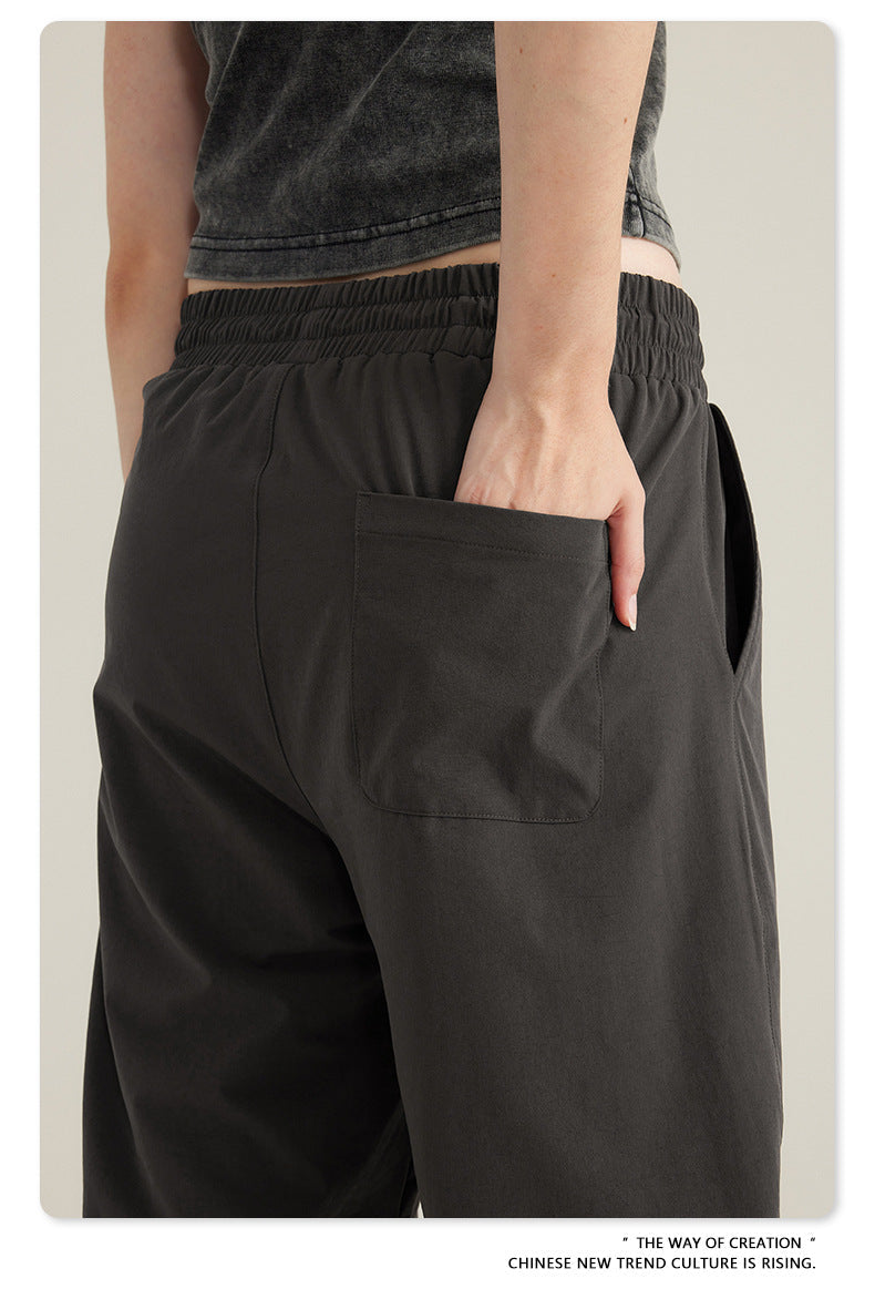 Close-up of hand in back pocket of black cargo pants with elasticated waist