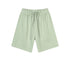 Light mint green cotton shorts with elastic waistband and drawstring, featuring side pockets and relaxed fit, displayed flat