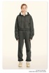 Model in charcoal loungewear with cropped hoodie and sweatpants. Wearing white headphones and cream sneakers