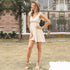 A model is showing off ivory tiered sundress with tie straps and frill hem detailing, paired with straw hat and white heeled sandals for resort wear