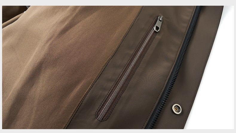 Interior pocket of a black and brown winter coat with a secure metal zipper, ideal for storing small essentials