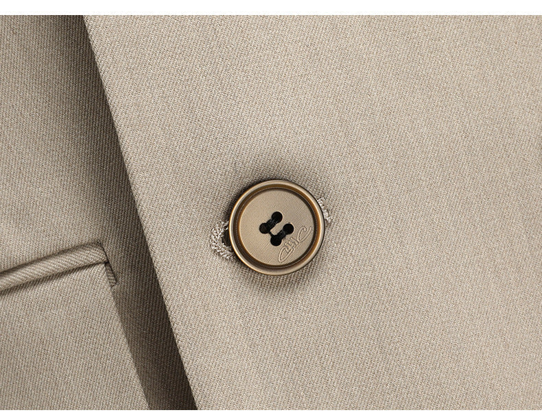 Detailed shot of premium suit button with decorative stitching on beige fabric