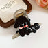 A playful black poodle-shaped hair claw with a red and white striped scarf, secured on a transparent clip.