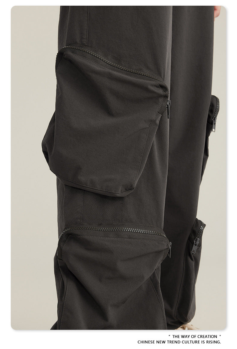 Detail of zippered utility pocket on black cargo pants showing stitch detail and construction
