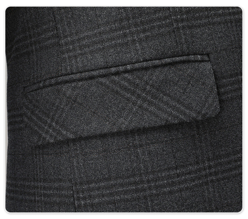 Detail of suit jacket pocket with subtle plaid pattern visible in dark gray fabric