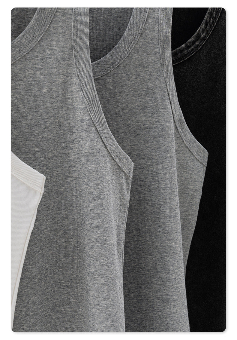 Close-up of gray and black tank tops hanging on a metal rack