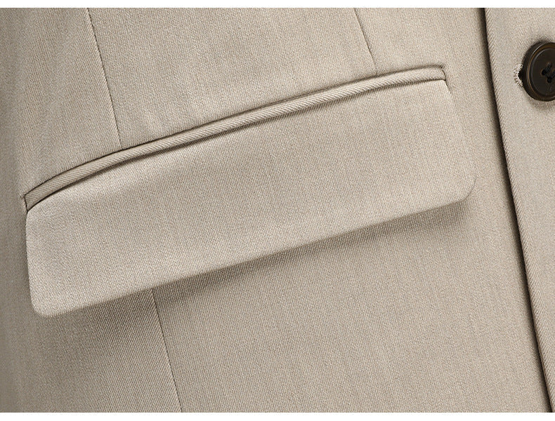 Close-up of beige suit jacket pocket with precise tailoring details